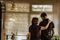 A mother stands and comforts her son in their home